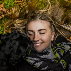Woman Laying on Grass with Dog